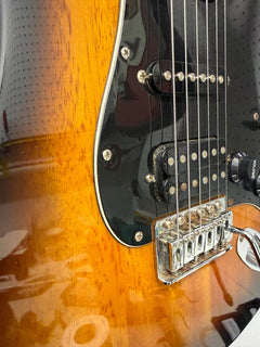Sunburst Squier Stratocaster with a black pickguard on the repair bench after cleaning and setup
