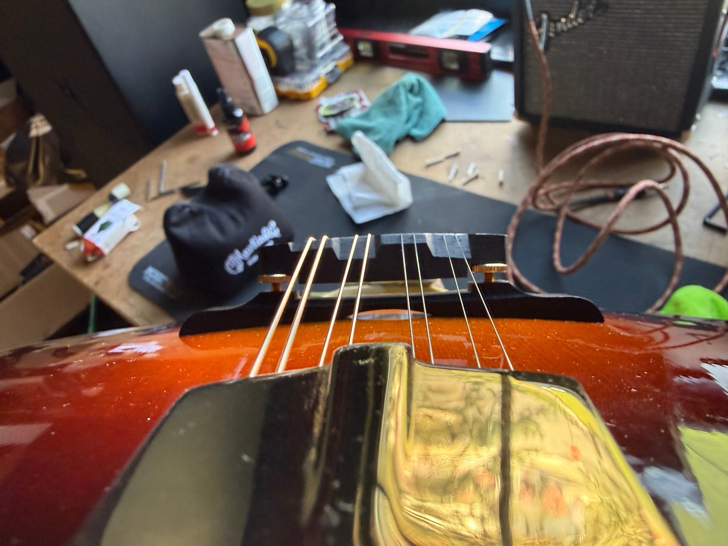 Bridge and tailpiece of a sunburst Eastman mandolin on the repair bench after the new bridge was fitted