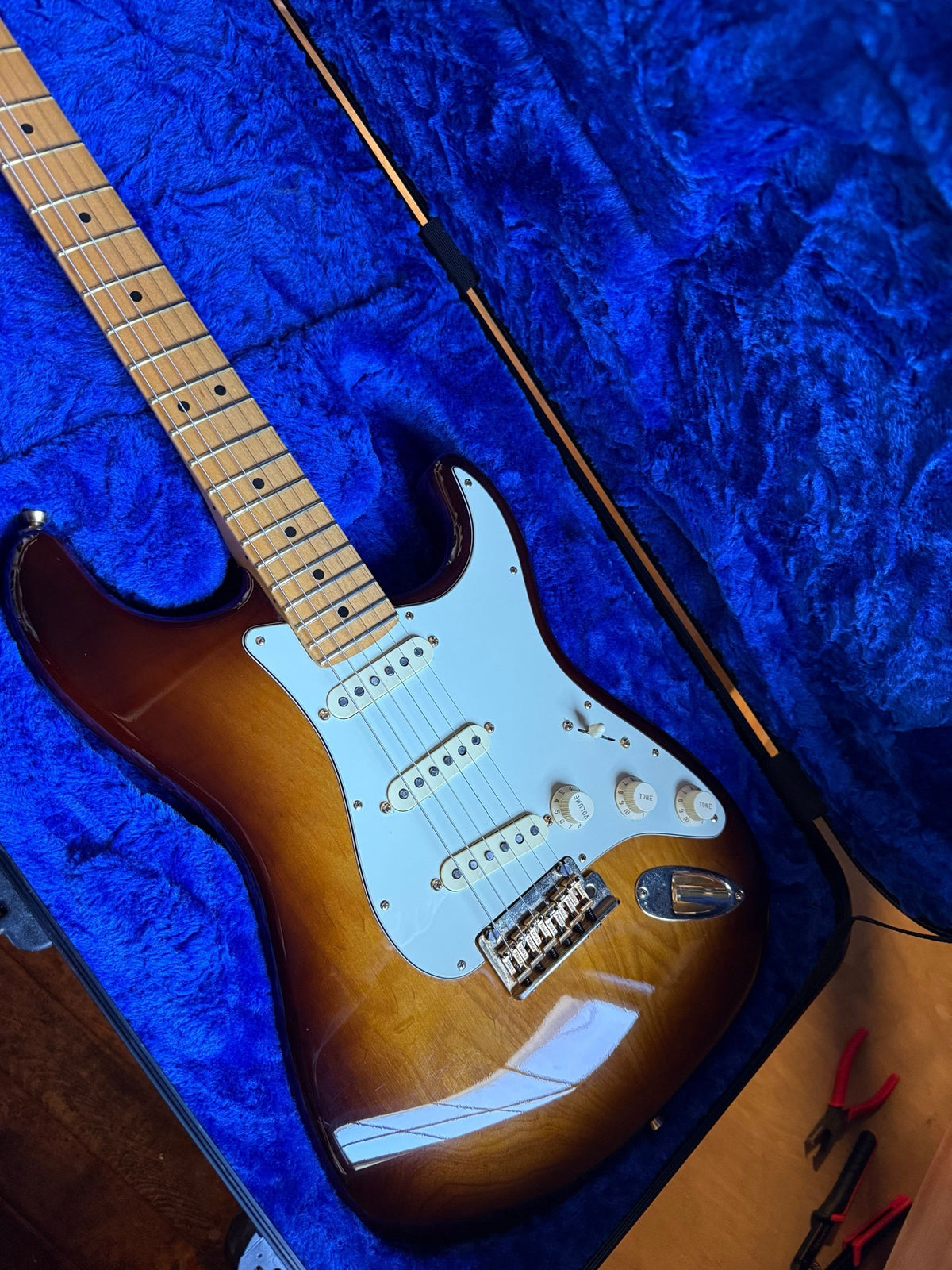 Fender 75th Anniversary Stratocaster in two-color sunburst in its case on the repair bench