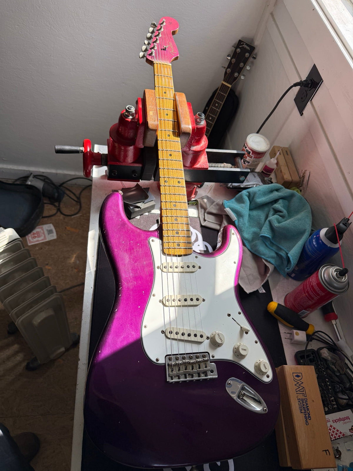 Purple metallic Fender Custom Shop Stratocaster with a maple neck on the repair bench