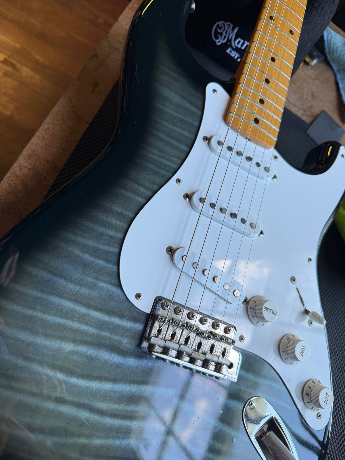 Japanese Fender Stratocaster with a blue-green burst flame top and maple neck on the repair bench