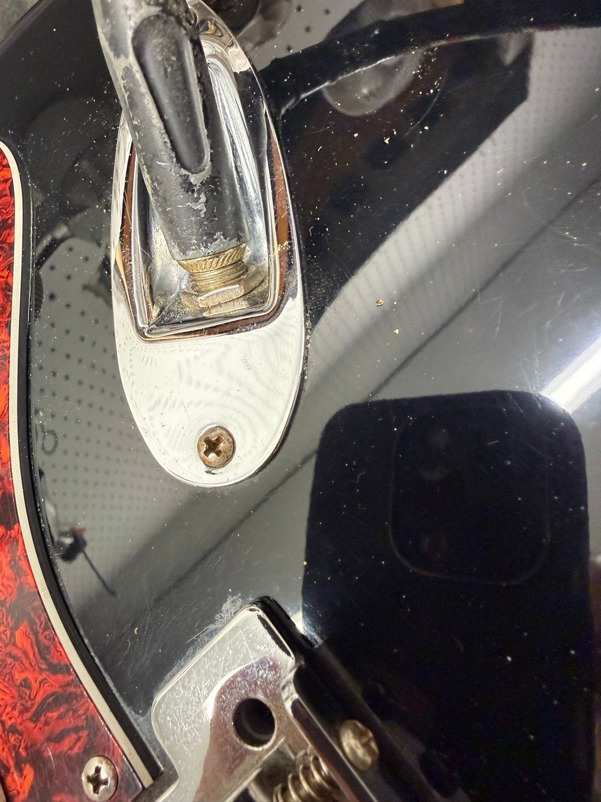 Black Fender Stratocaster with a tortoise pickguard on the repair bench