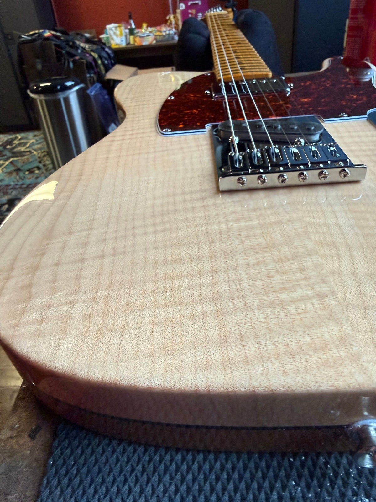 Fender Telecaster with a natural flame maple top and tortoise pickguard on the repair bench