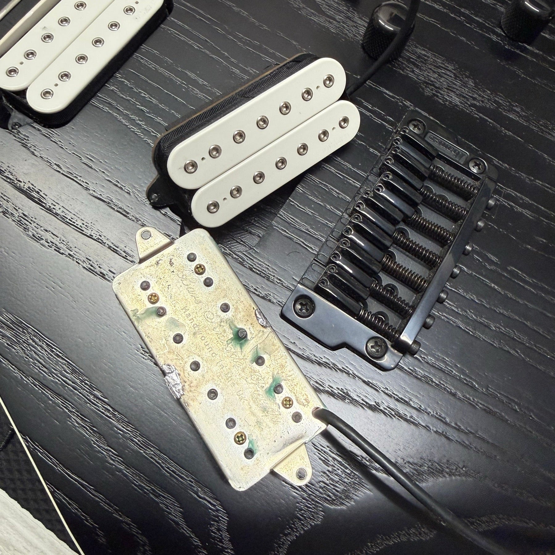 Ibanez seven-string electric on the repair bench for a bridge pickup swap