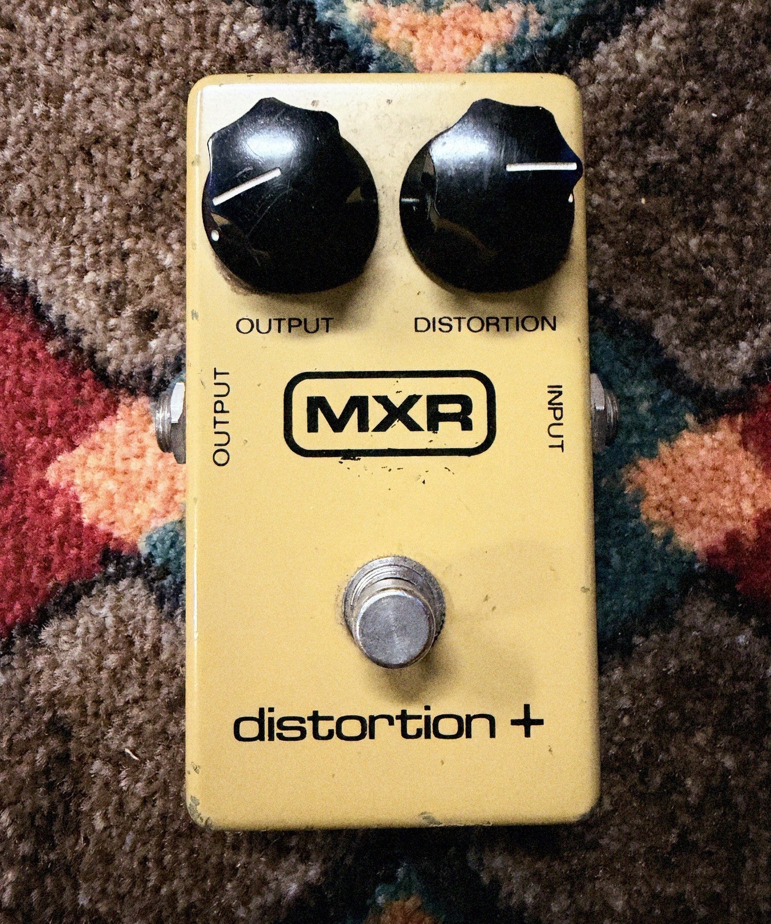 MXR Distortion+, yellow: top with the Output and Distortion knobs, the block MXR logo and the footswitch, no LED