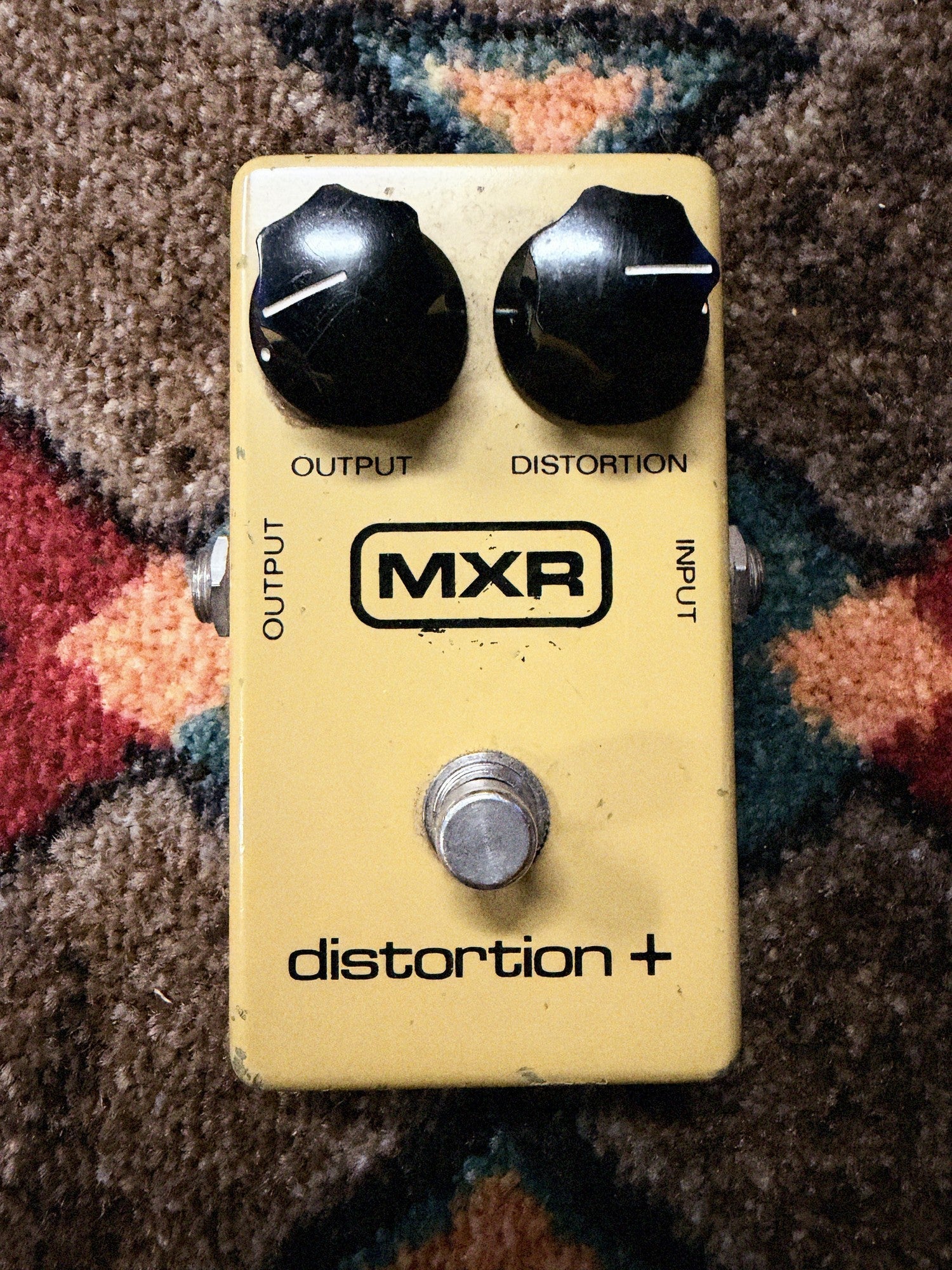 MXR Distortion+, yellow: top with the Output and Distortion knobs, the block MXR logo and the footswitch, no LED