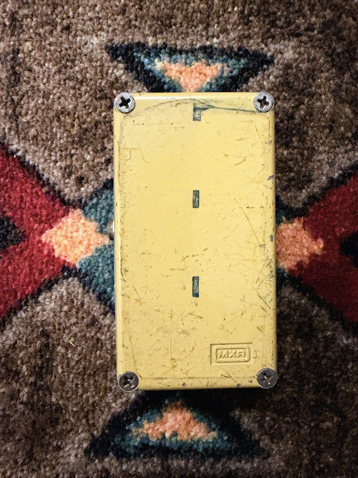 MXR Distortion+, yellow: bottom plate with the embossed MXR logo, four screws and dark marks