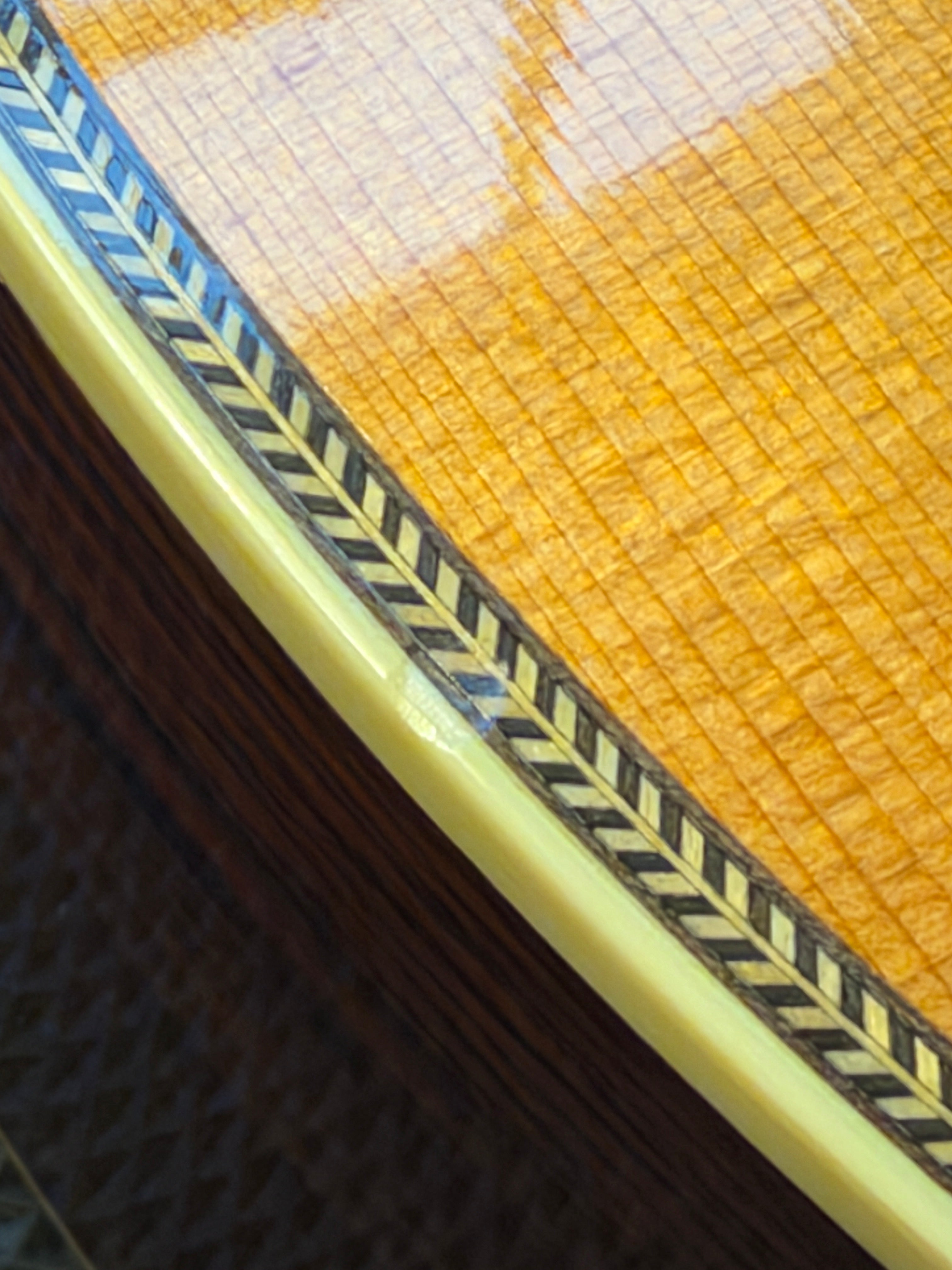 Martin 000C-28SMH Merle Haggard Blue Yodel No. 13, 2001: top edge close up, herringbone purfling and cream binding over the rosewood side, fine checking in the top's finish