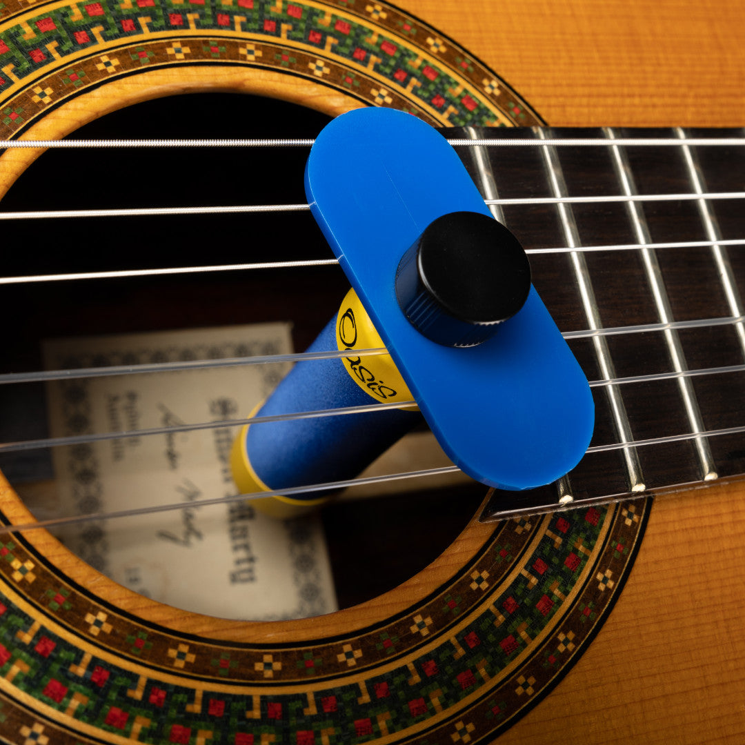 Blue Oasis OH-1 humidifier on its stabilizer bar, resting across the strings in a classical guitar soundhole