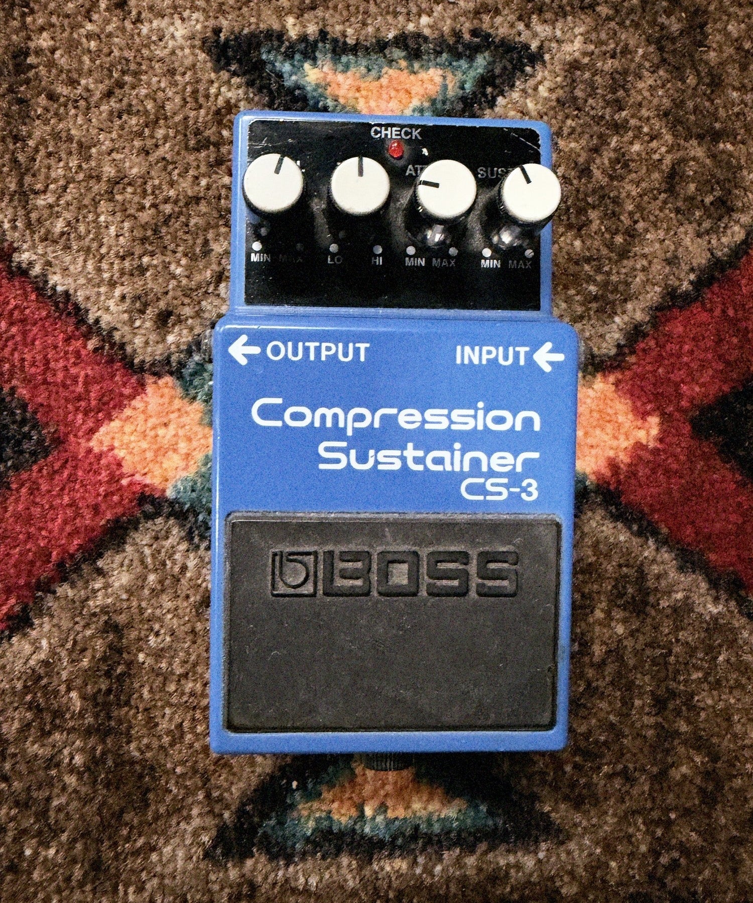 Boss CS-3 Compression Sustainer, blue: top with the Level, Tone, Attack and Sustain knobs, the check light and the footswitch