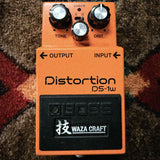 Boss DS-1W Waza Craft Distortion, orange: top with the Tone, Level and Dist knobs, the S and C mode switch, the Check light and the Waza Craft pedal