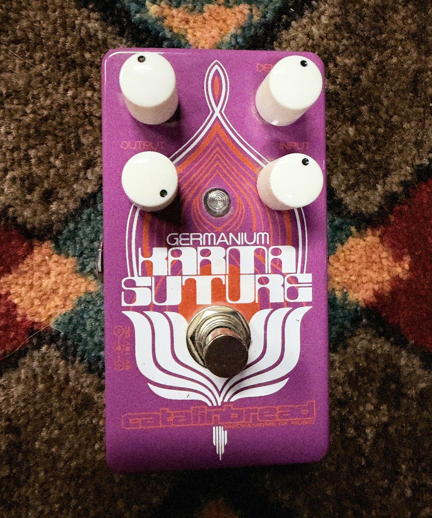 Catalinbread Karma Suture Germanium, purple: top with the four white knobs, the Germanium Karma Suture artwork, the LED and the footswitch