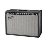 Fender '65 Deluxe Reverb combo amp from the front left, black textured vinyl cabinet with the Fender logo on the silver grille