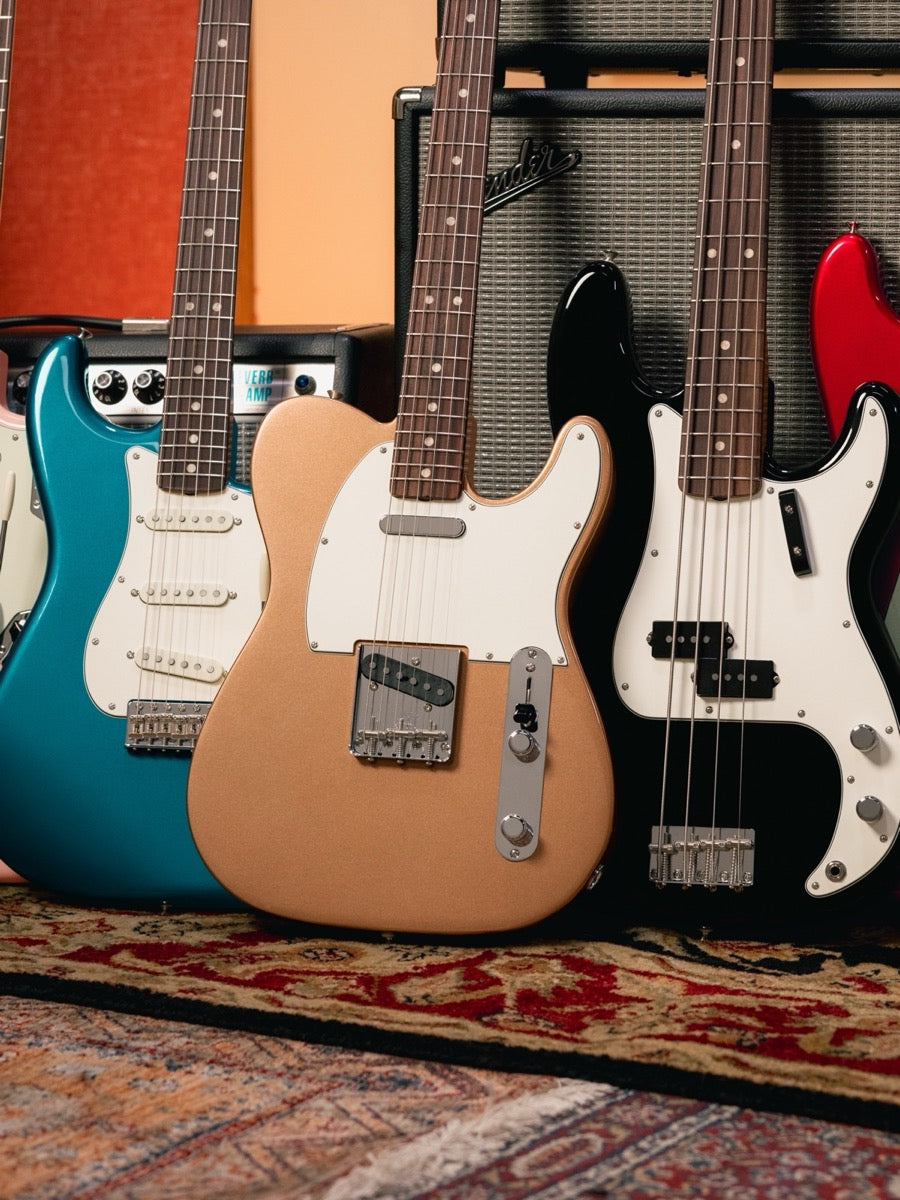 Fender guitars against vintage amps — portrait crop for mobile. Authorized Fender dealer.