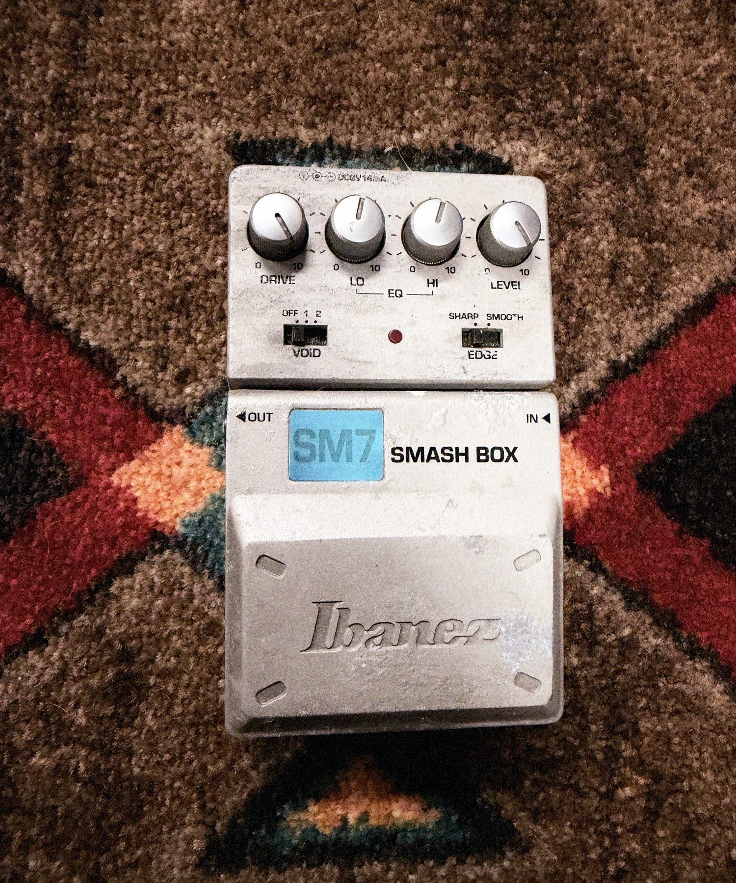Ibanez SM7 Smash Box, silver: top with the Drive, Lo, Hi and Level knobs, the Void and Edge switches, the LED and the Ibanez pedal, its finish worn beside the logo