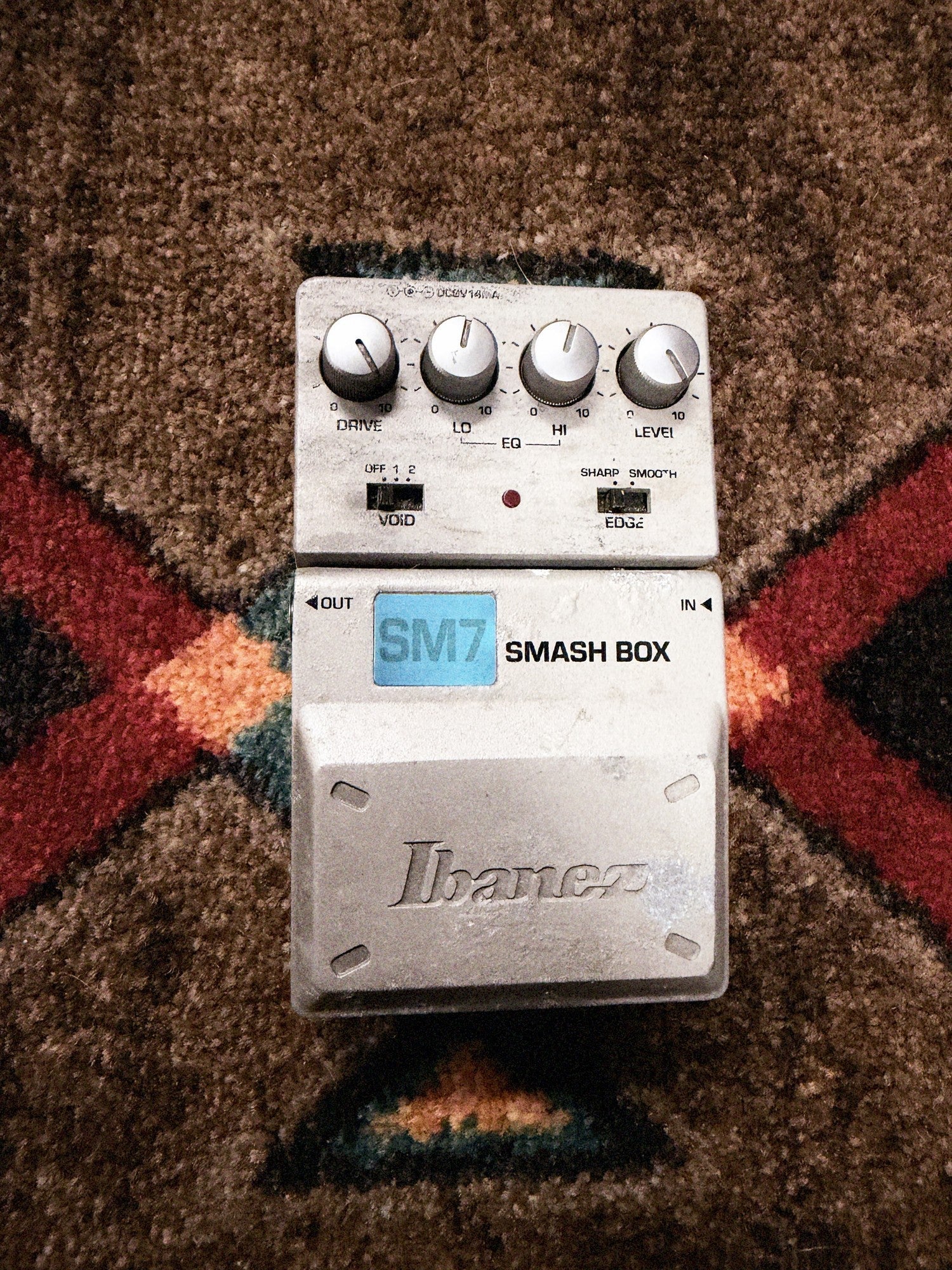 Ibanez SM7 Smash Box, silver: top with the Drive, Lo, Hi and Level knobs, the Void and Edge switches, the LED and the Ibanez pedal, its finish worn beside the logo