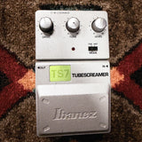 Ibanez TS7 Tube Screamer, silver: top with the Drive, Tone and Level knobs, the TS9 and Hot mode switch, the LED, the green TS7 label and the Ibanez pedal