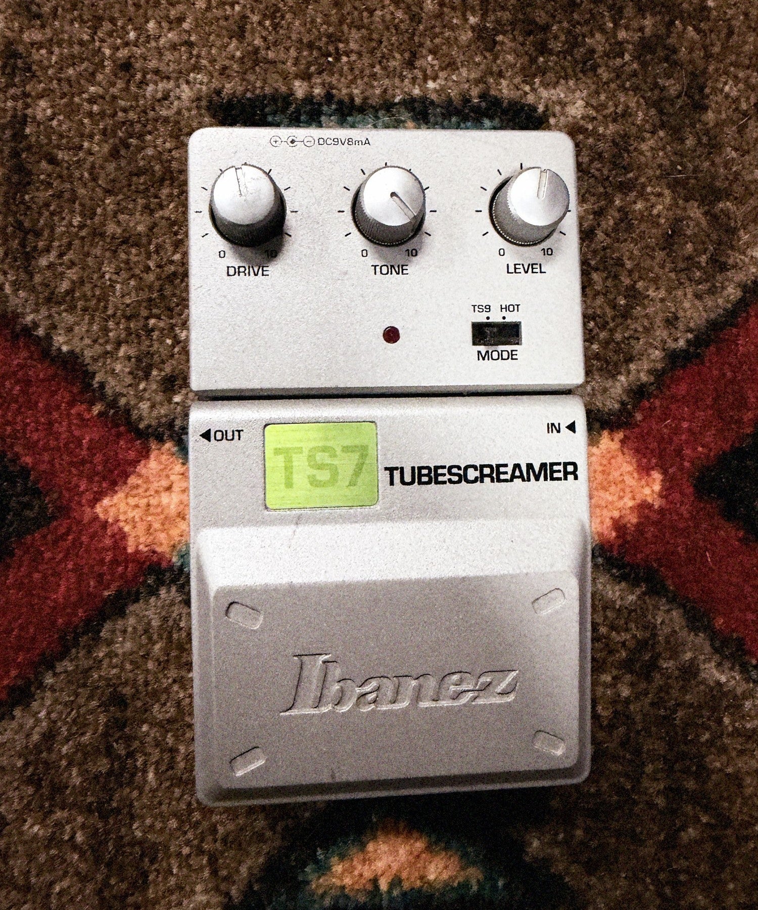Ibanez TS7 Tube Screamer, silver: top with the Drive, Tone and Level knobs, the TS9 and Hot mode switch, the LED, the green TS7 label and the Ibanez pedal