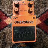KMD Overdrive, orange: top with the Treble, Bass, Level and Drive knobs, the LED and the black kmd pedal pad