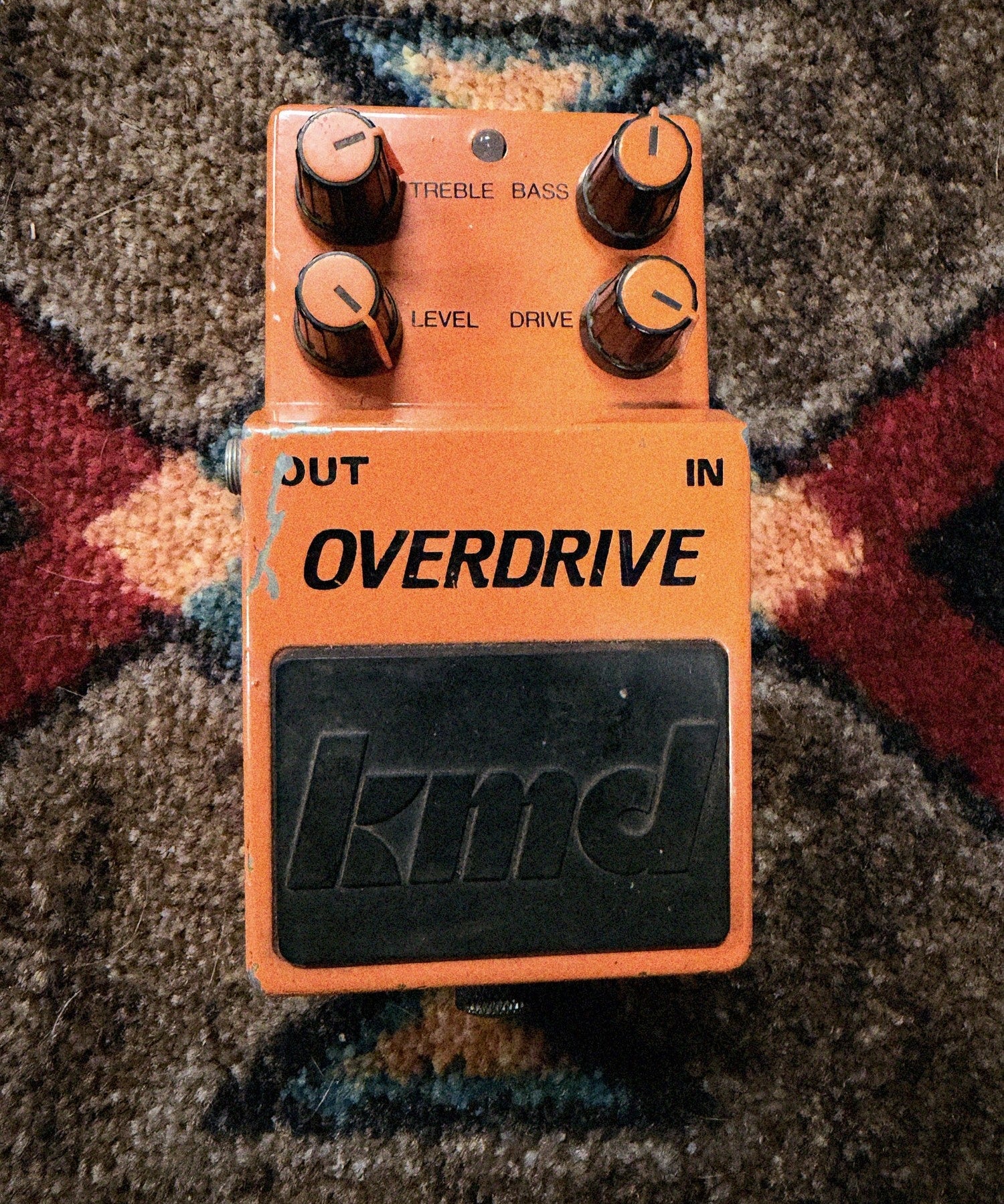 KMD Overdrive, orange: top with the Treble, Bass, Level and Drive knobs, the LED and the black kmd pedal pad