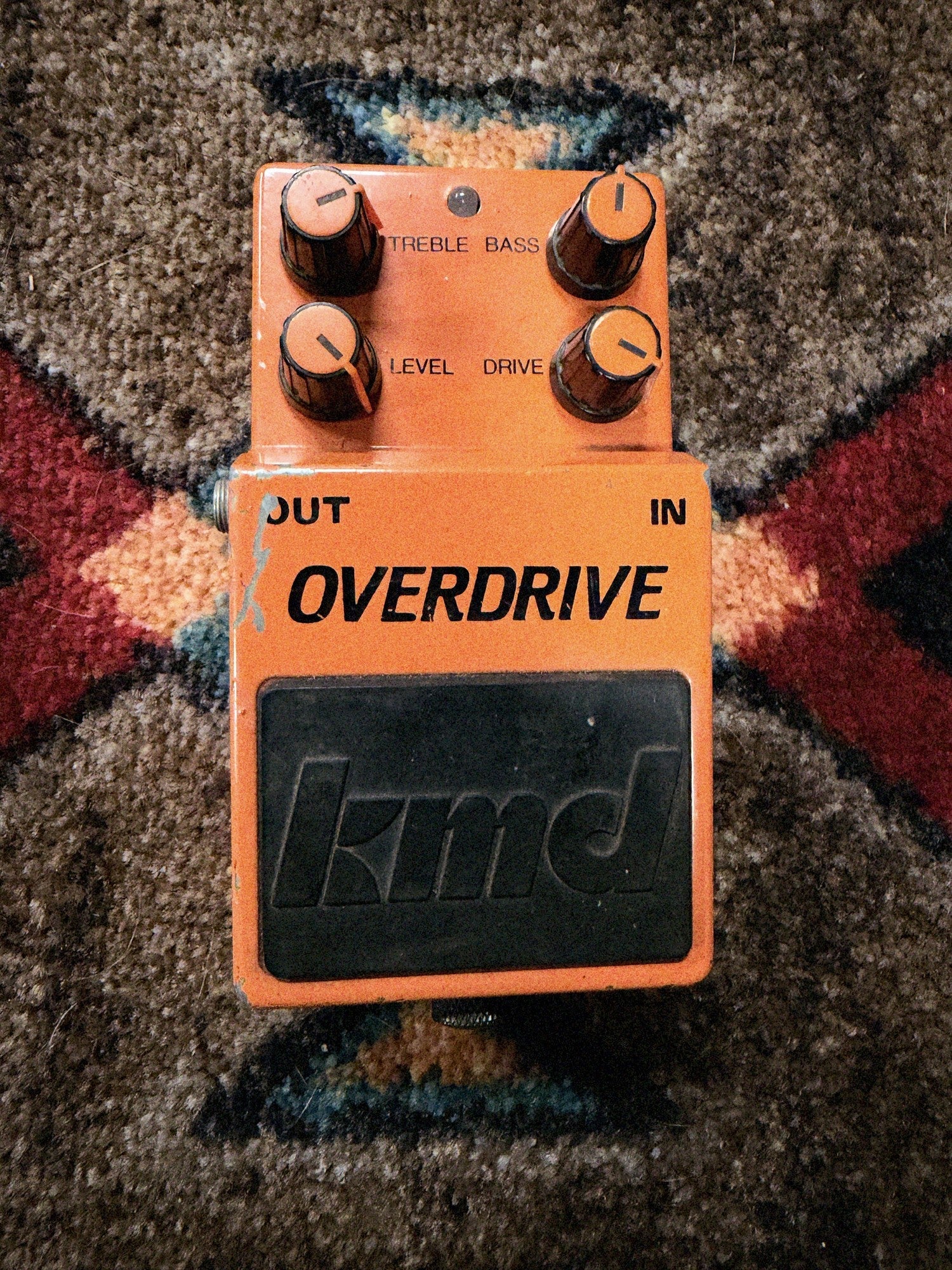 KMD Overdrive, orange: top with the Treble, Bass, Level and Drive knobs, the LED and the black kmd pedal pad