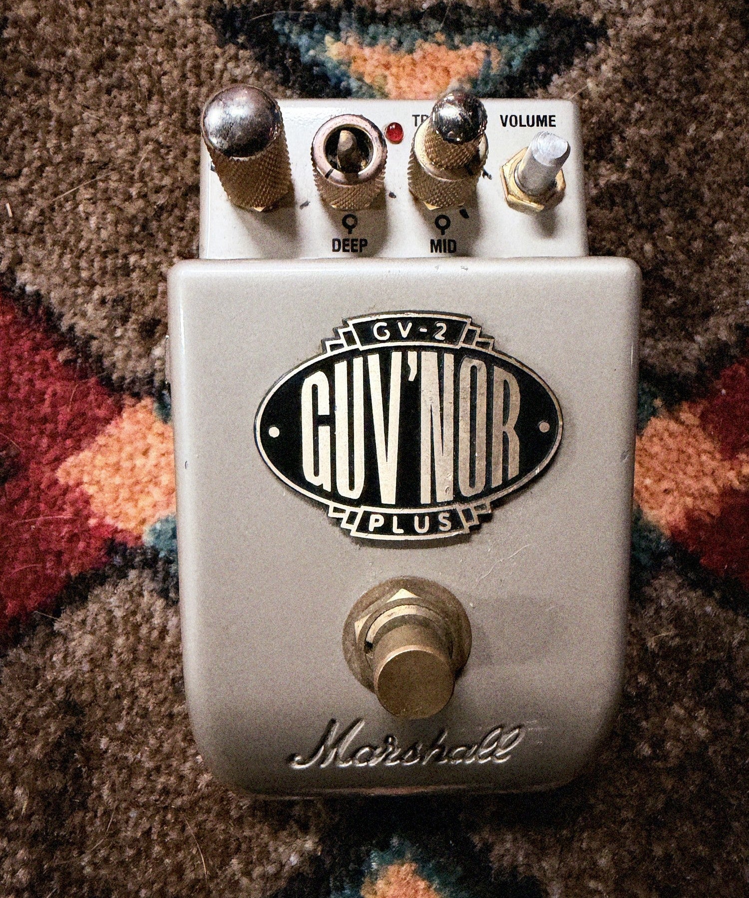 Marshall GV-2 Guv'nor Plus, silver: top with the Gain knob, the Deep and Mid rings, the Treble knob, the bare Bass and Volume shafts, the badge and the footswitch