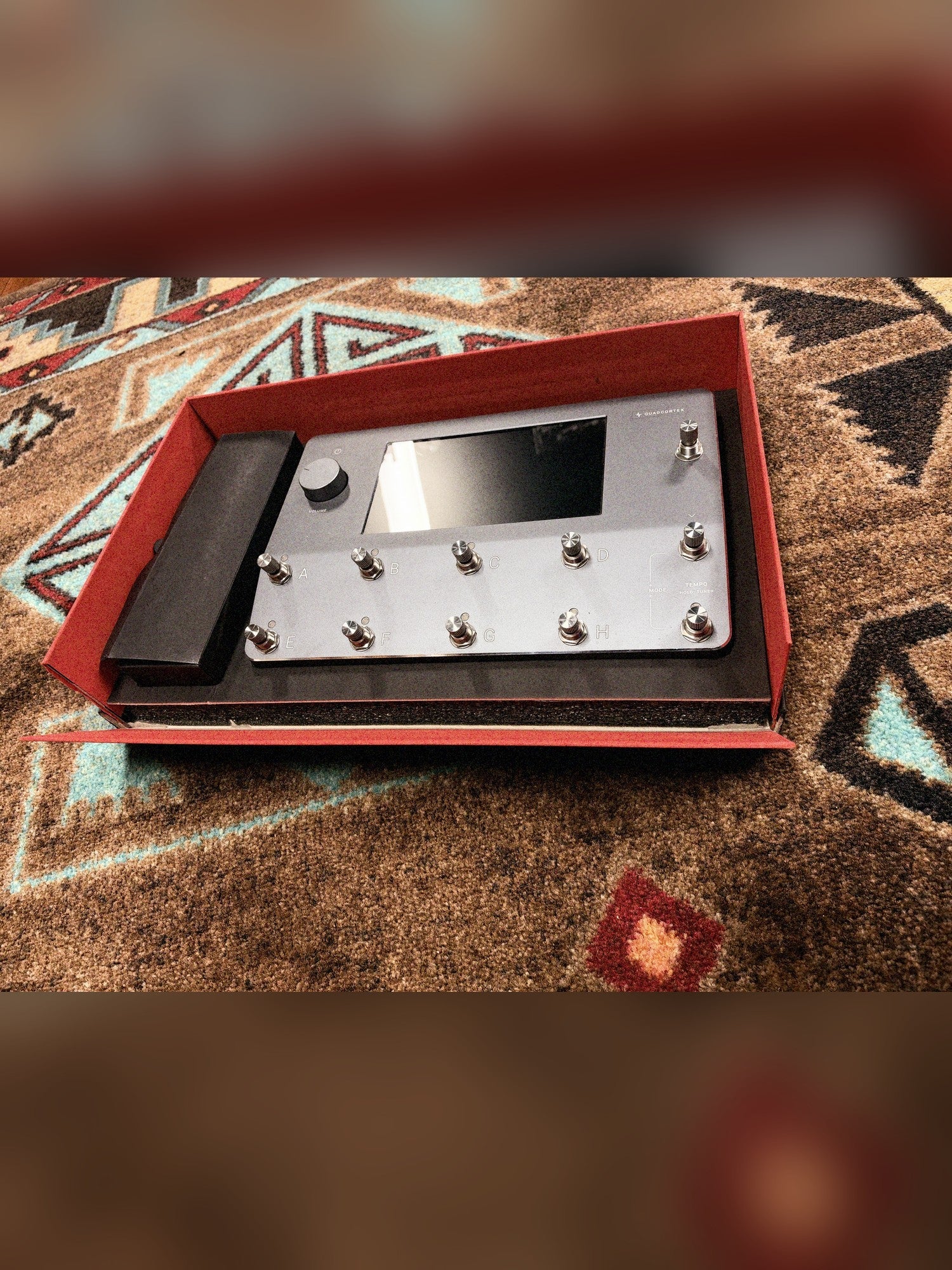 Neural DSP Quad Cortex, gray: the unit sitting in its open box with the red lining