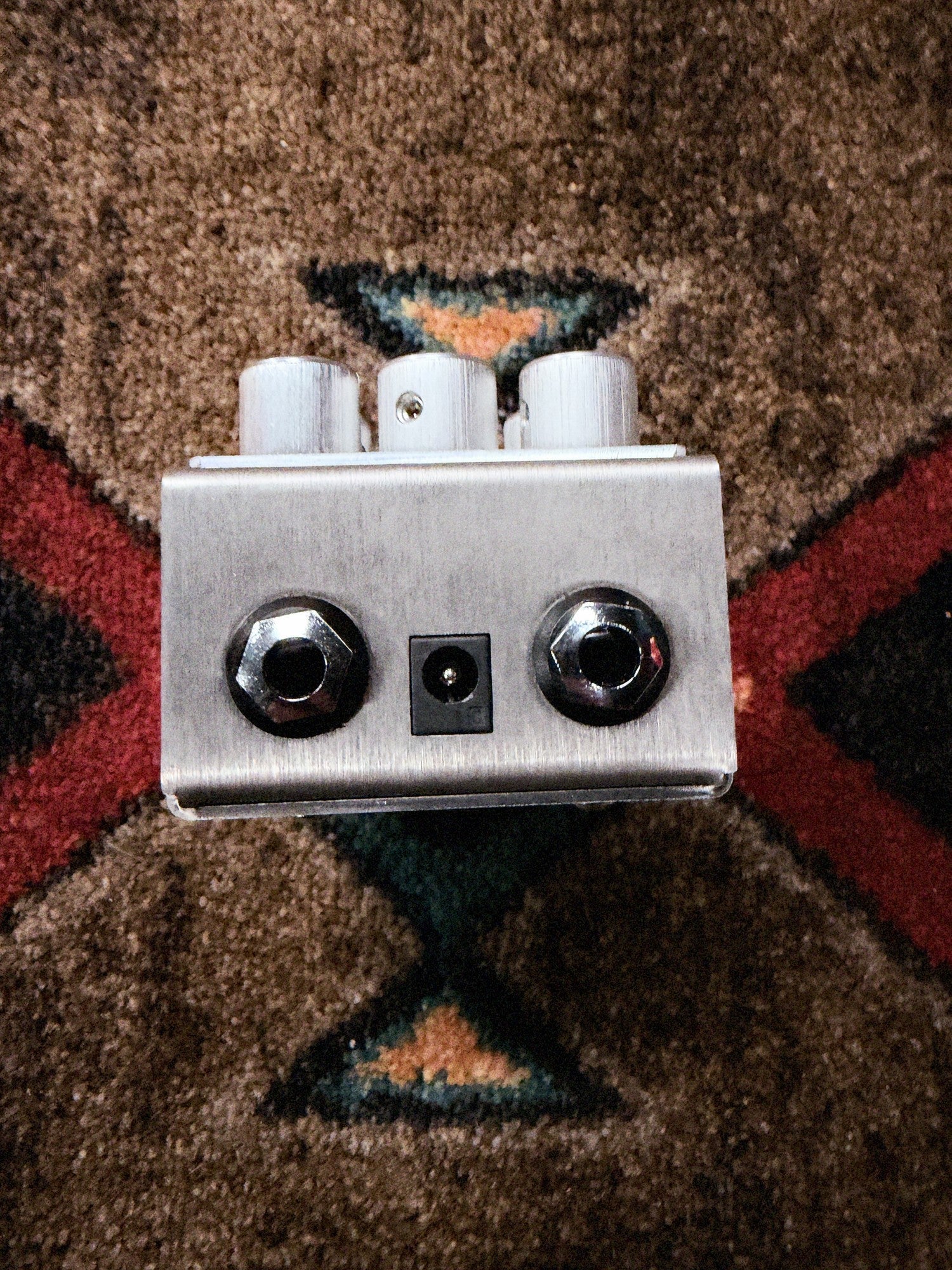 Origin Effects Cali76 Bass Compressor, silver: jack end with the two 1/4 inch jacks and the power jack between them