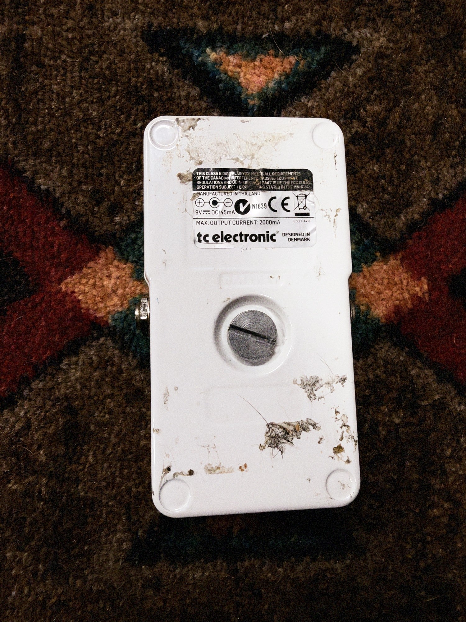 TC Electronic PolyTune Poly-Chromatic Tuner, white: bottom with the battery thumbscrew, glue marks and the label reading Manufactured in Thailand, 9V DC 45mA