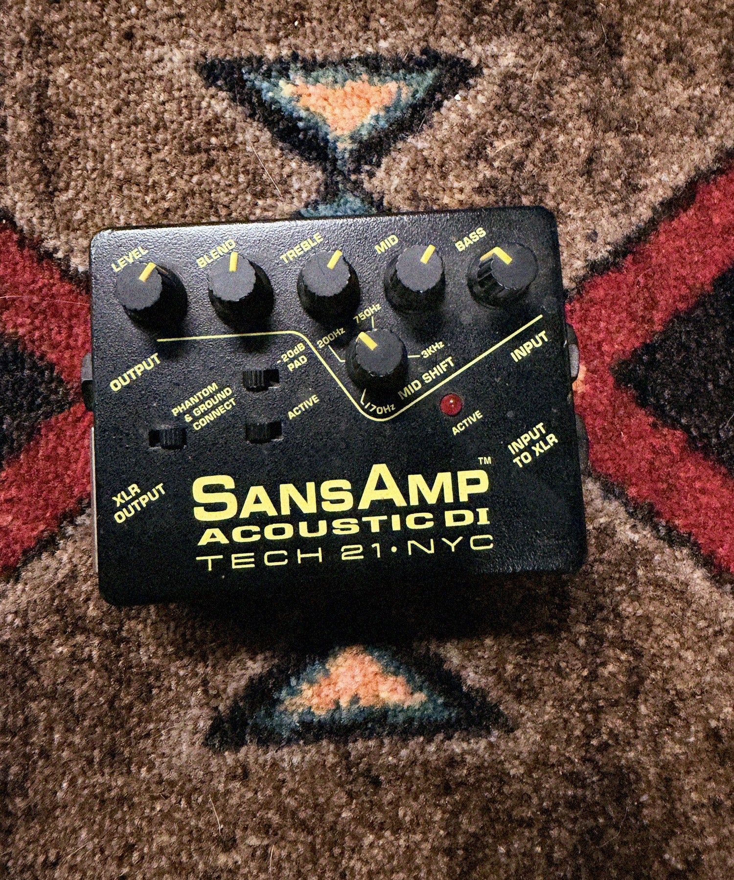 Tech 21 SansAmp Acoustic DI, black: top with the Level, Blend, Treble, Mid, Bass and Mid Shift knobs, the Pad, Phantom and Active switches and the Active LED