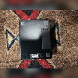 Tech 21 SansAmp Acoustic DI, black: bottom with the battery door and the label reading Tech 21, 201404, Made in U.S.A.