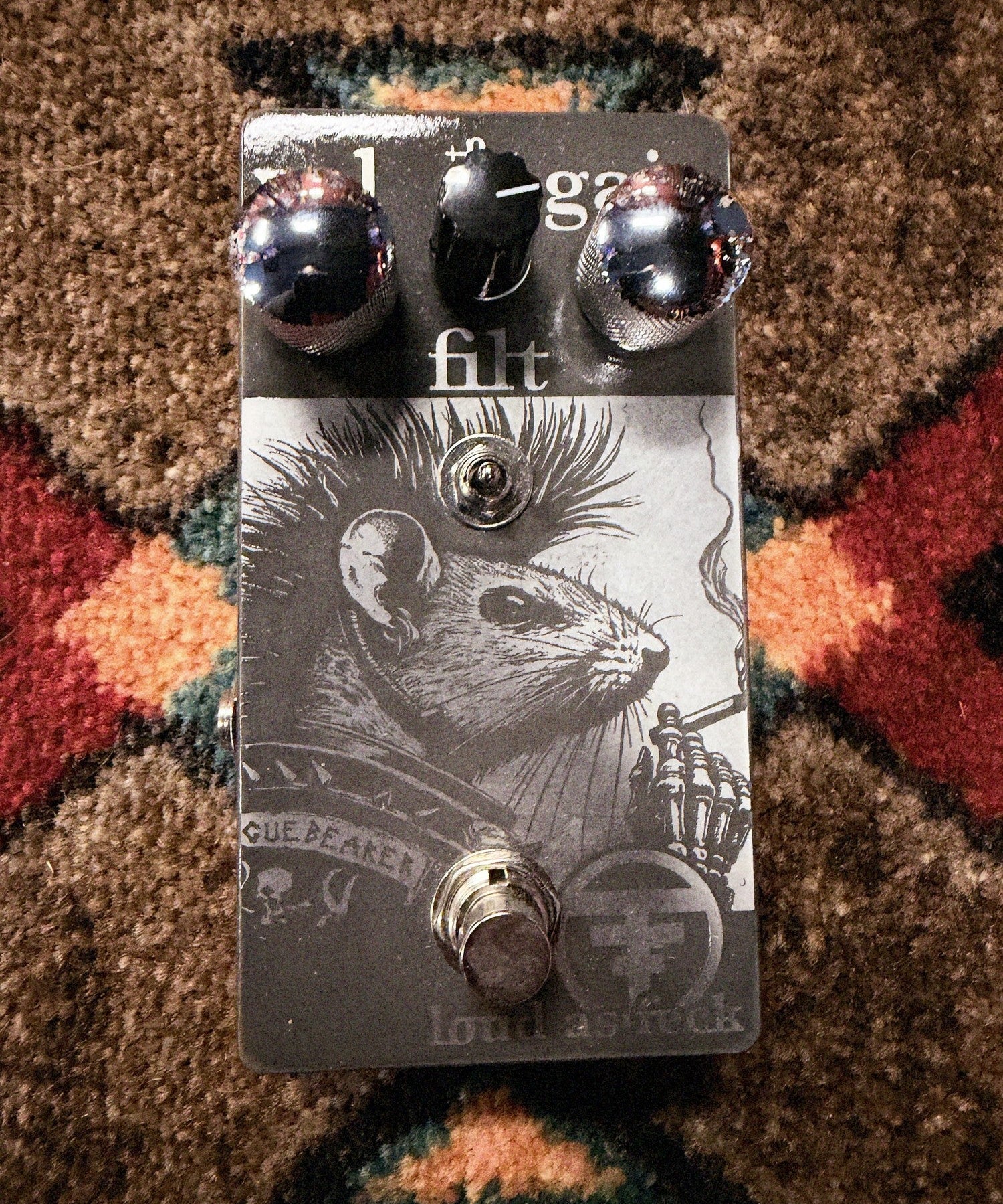 Tone Collector Custom The Plaguebearer, gray: top with the Vol, Gain and Filt knobs, the toggle, the rat and skull artwork and the footswitch